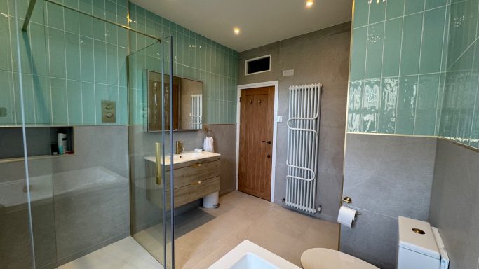 Modern bathroom featuring a glass shower, vanity unit, and neutral decor.
